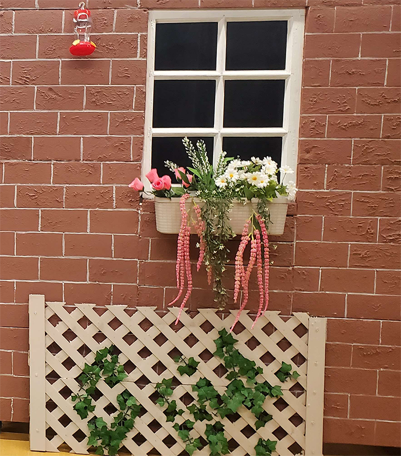 A set for a stage production decorated to look like the outside of a house.